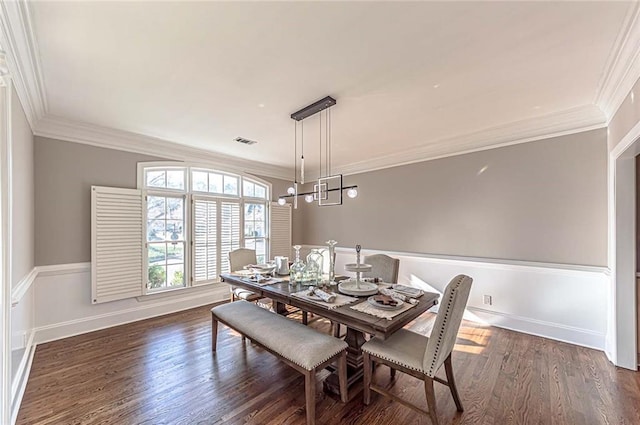 dining room featuring dark wood-style flooring, ornamental molding, baseboards, and visible vents