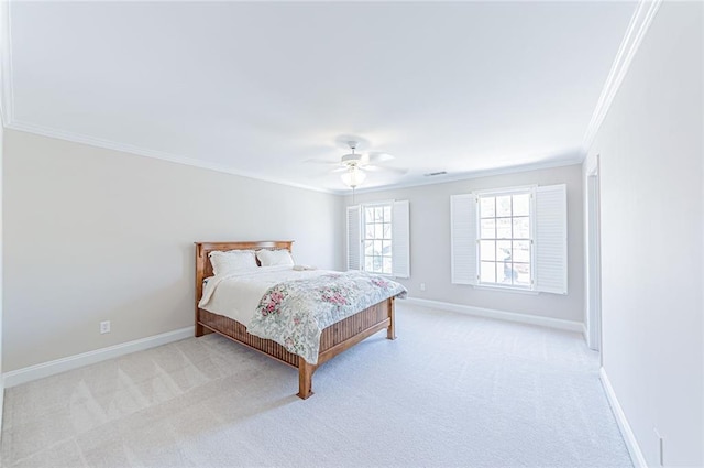 carpeted bedroom with baseboards, crown molding, and a ceiling fan