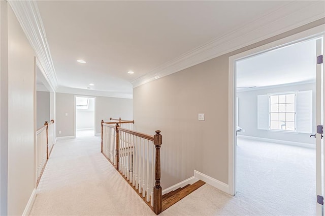corridor featuring light carpet, ornamental molding, plenty of natural light, and an upstairs landing