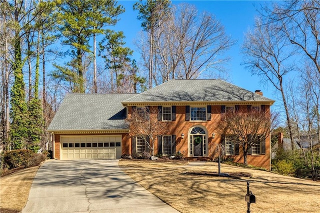 view of front facade featuring driveway, brick siding, and an attached garage