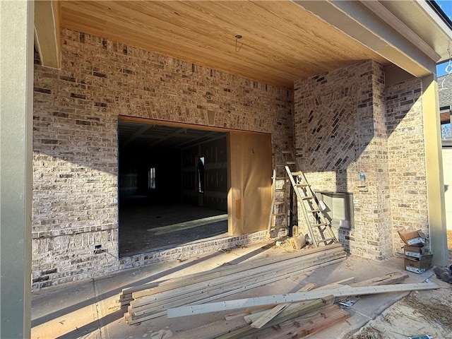 miscellaneous room featuring wooden ceiling and brick wall