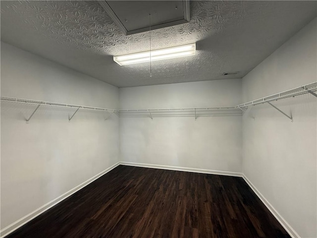 spacious closet with attic access and wood finished floors