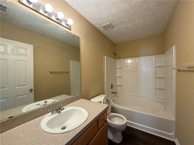 full bathroom with a textured ceiling, shower / bathtub combination, toilet, wood finished floors, and vanity