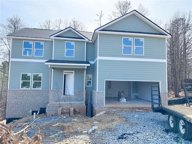 view of front facade featuring a garage, a patio area, brick siding, and driveway