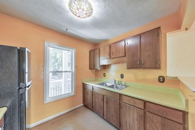 350 Pleasant Oak Ct SW, Marietta, GA 30008 - kitchen featuring freestanding refrigerator, a sink, a textured ceiling, light countertops, and baseboards
