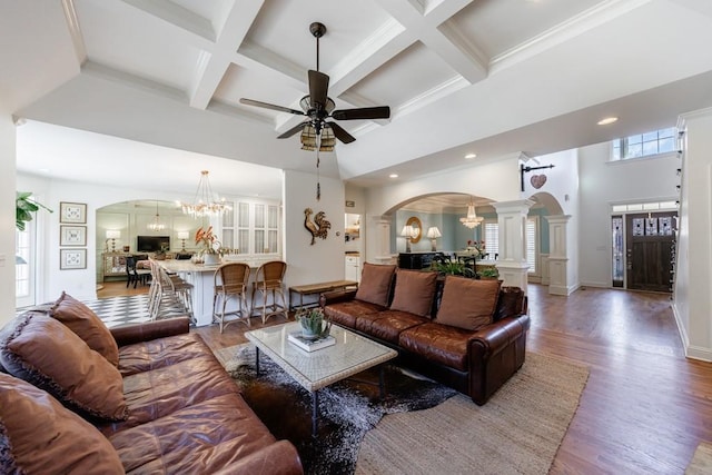 living room featuring arched walkways, coffered ceiling, a towering ceiling, and wood finished floors