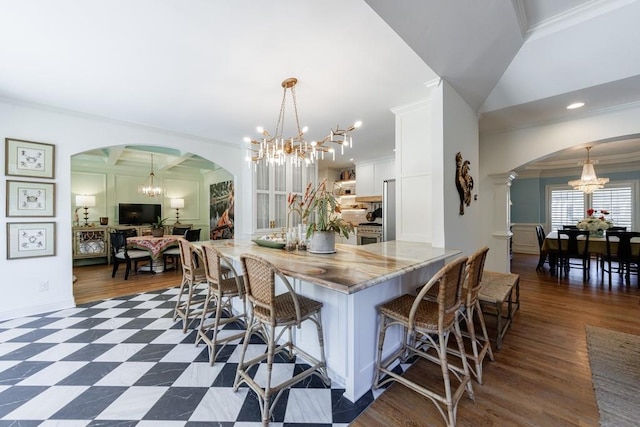 kitchen with crown molding, a notable chandelier, and arched walkways