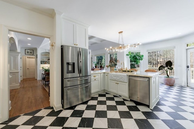 kitchen featuring white cabinetry, stainless steel appliances, a peninsula, dark floors, and light countertops