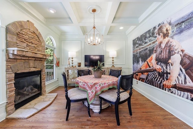 dining space featuring a fireplace, beam ceiling, wood finished floors, and coffered ceiling