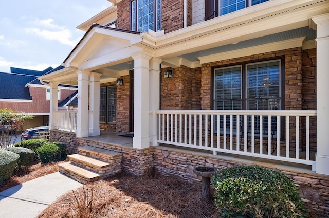 property entrance featuring stone siding and a porch