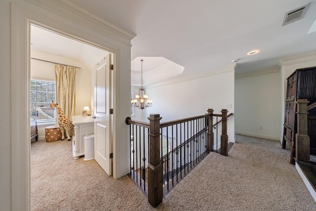 corridor featuring visible vents, an upstairs landing, carpet floors, and ornamental molding