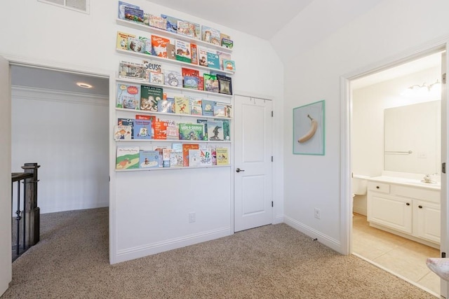 bedroom with visible vents, a sink, connected bathroom, baseboards, and light colored carpet