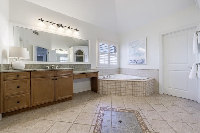 full bathroom featuring tile patterned floors, visible vents, a bath, a towering ceiling, and vanity