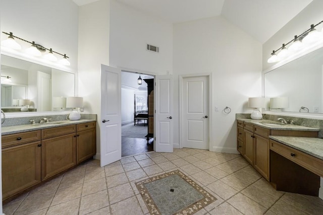 full bath with a sink, visible vents, two vanities, and ensuite bathroom