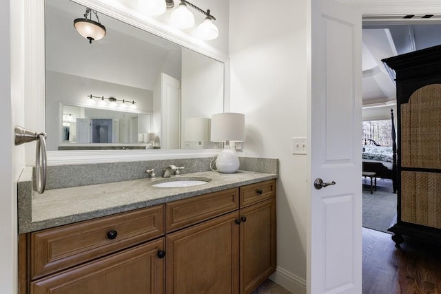 bathroom featuring vanity, wood finished floors, and baseboards