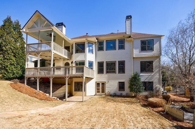 rear view of house featuring french doors, a chimney, and ceiling fan