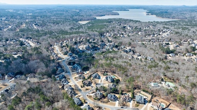 drone / aerial view with a water view and a wooded view