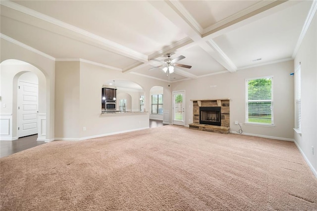 212 Jetta Cir, Mcdonough, GA 30253 - unfurnished living room with carpet, a ceiling fan, baseboards, a stone fireplace, and beamed ceiling