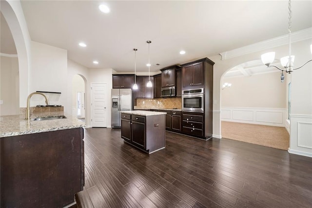 212 Jetta Cir, Mcdonough, GA 30253 - kitchen with appliances with stainless steel finishes, a sink, arched walkways, a chandelier, and a wainscoted wall