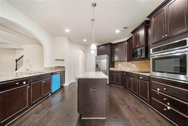212 Jetta Cir, Mcdonough, GA 30253 - kitchen with appliances with stainless steel finishes, a sink, arched walkways, tasteful backsplash, and light stone counters