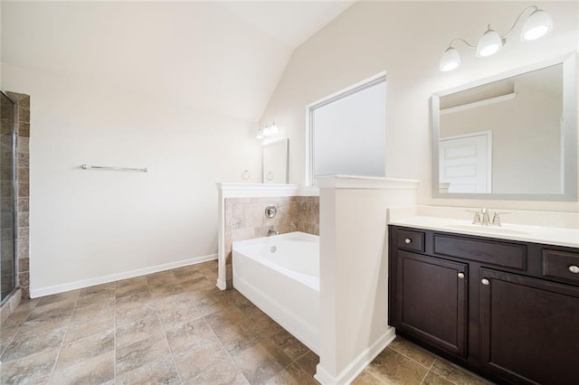 212 Jetta Cir, Mcdonough, GA 30253 - bathroom featuring a garden tub, vanity, vaulted ceiling, baseboards, and stone finish floors