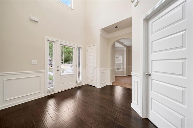 212 Jetta Cir, Mcdonough, GA 30253 - foyer featuring arched walkways, a wainscoted wall, dark wood-style flooring, a decorative wall, and a towering ceiling