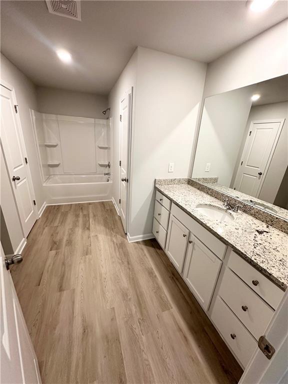 321 Lambert Overlook Cir, Carrollton, GA 30117 - full bathroom featuring vanity, wood finished floors, washtub / shower combination, baseboards, and recessed lighting