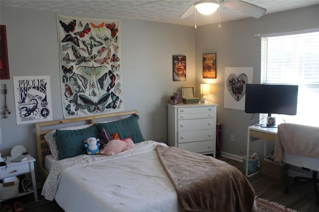 bedroom featuring ceiling fan, wood-type flooring, and a textured ceiling