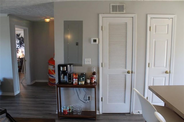 interior space with dark hardwood / wood-style flooring, electric panel, and a textured ceiling