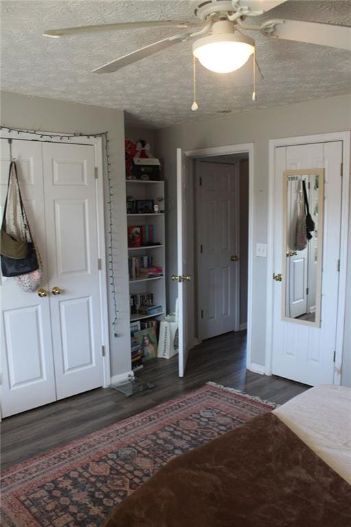 unfurnished bedroom with dark wood-type flooring, ceiling fan, and a textured ceiling