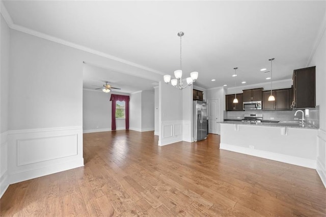 6535 Crosscreek Ln, Flowery Branch, GA 30542 - unfurnished living room with a chandelier, light wood finished floors, a wainscoted wall, ceiling fan, and ornamental molding
