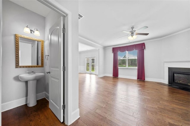 6535 Crosscreek Ln, Flowery Branch, GA 30542 - unfurnished living room with wood finished floors, a ceiling fan, ornamental molding, and a fireplace with flush hearth