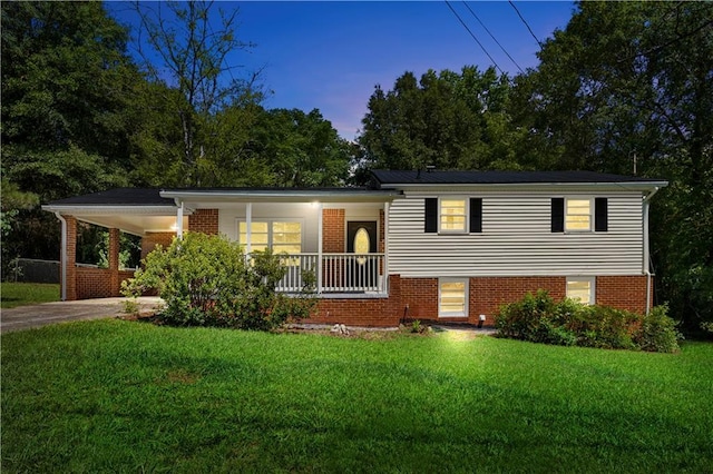 split level home with covered porch and a lawn