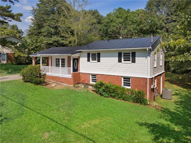 tri-level home featuring cooling unit, a front lawn, and covered porch