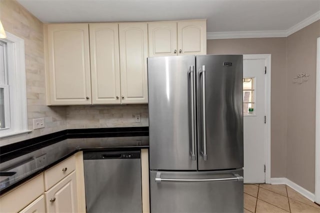 kitchen featuring stainless steel appliances, ornamental molding, cream cabinets, and light tile patterned floors