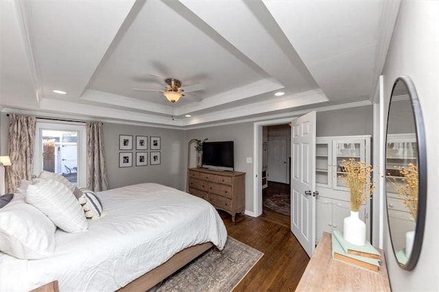 bedroom featuring dark wood-type flooring, ceiling fan, a tray ceiling, and crown molding