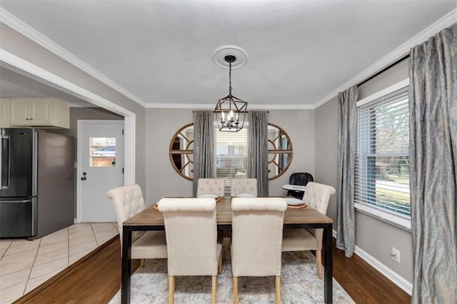 dining room with ornamental molding, a healthy amount of sunlight, and a chandelier