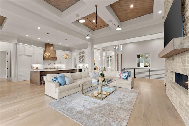 living area featuring recessed lighting, beamed ceiling, coffered ceiling, and light wood finished floors