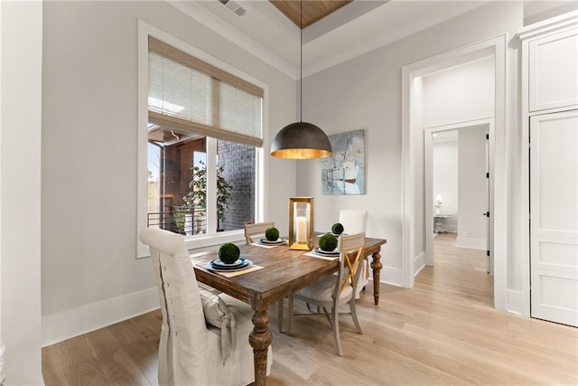 dining area with light wood finished floors, visible vents, and baseboards