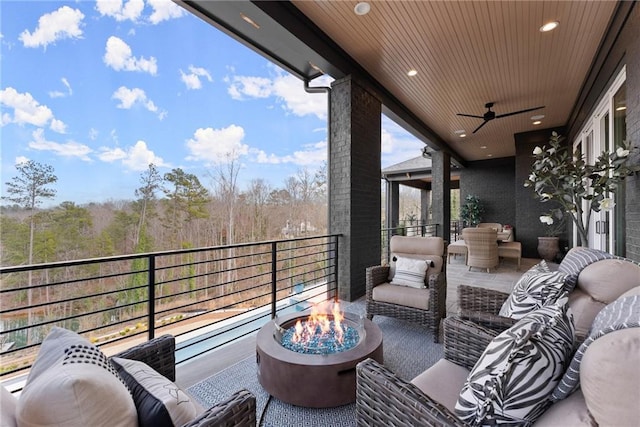 balcony featuring an outdoor living space with a fire pit and a ceiling fan