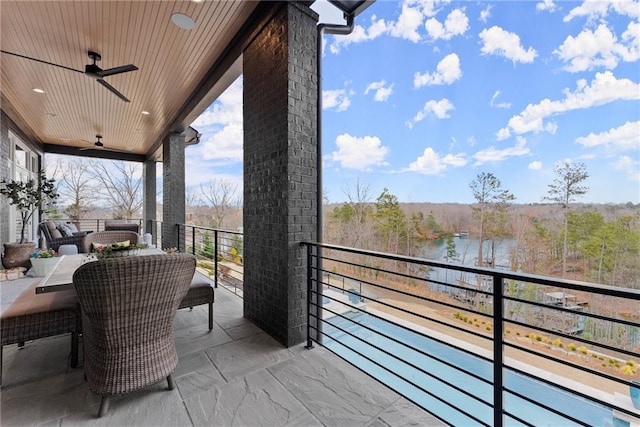 balcony with a water view and ceiling fan