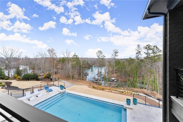 view of pool featuring a patio area, fence, and a water view