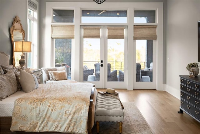 bedroom with wood finished floors, access to outside, and french doors