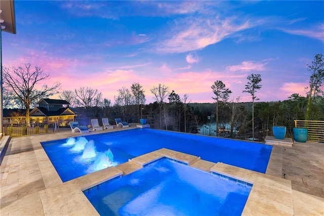 view of swimming pool featuring a patio area, fence, and a pool with connected hot tub