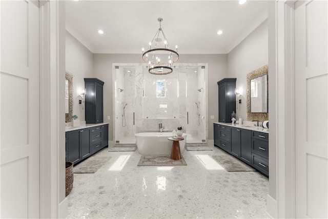 full bathroom featuring two vanities, a stall shower, a sink, an inviting chandelier, and a freestanding bath