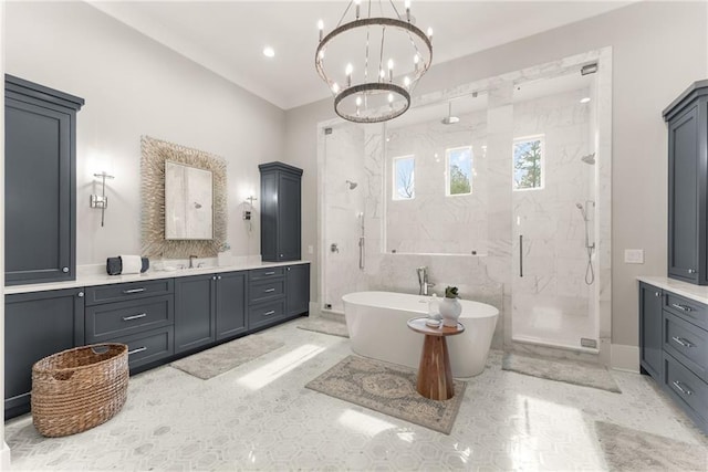 full bath with a marble finish shower, a freestanding bath, an inviting chandelier, and vanity