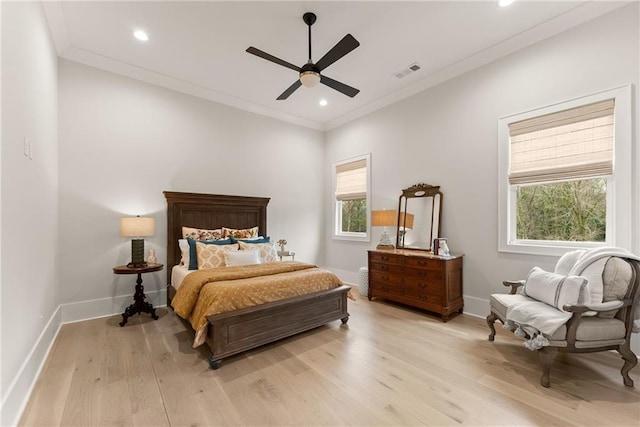 bedroom featuring baseboards, light wood-style floors, visible vents, and ornamental molding