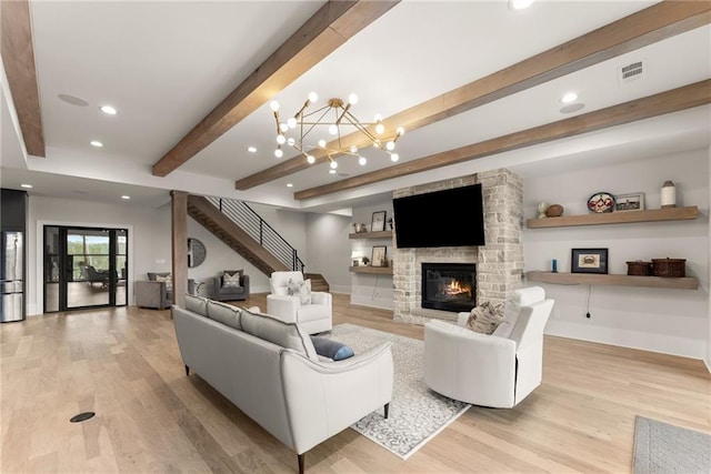 living room with beam ceiling, visible vents, light wood finished floors, and a fireplace