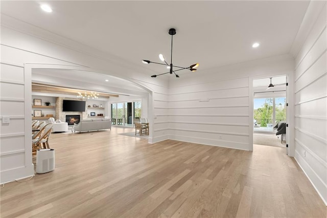 living room featuring a wealth of natural light, light wood-style floors, a chandelier, and crown molding