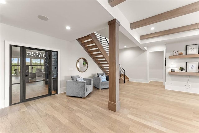 unfurnished living room with baseboards, recessed lighting, stairs, light wood-style floors, and beamed ceiling